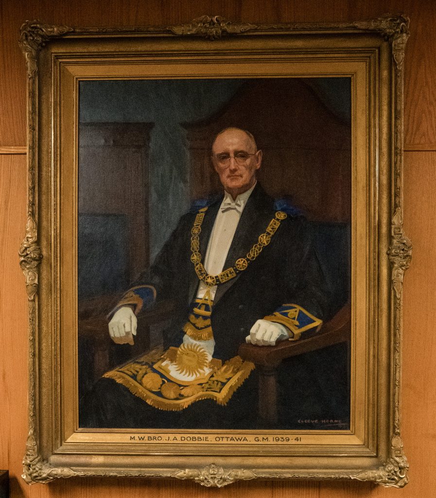 Historic painted portrait of a past Grand Master associated with Ottawa District 2 Freemasons, displayed in an ornate gold frame, depicting traditional Masonic regalia and formal attire in an early-20th-century style.