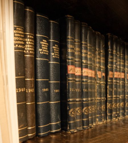 Shelf of vintage Masonic proceedings and Grand Lodge records bound in dark leather, showing decades of archival volumes preserved within Ottawa District 2’s historical collection.